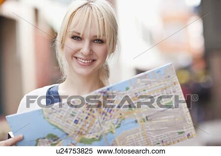 USA, Seattle, Smiling young woman holding map View Large Photo Image Stock Photography - USA, Seattle, Smiling young woman holding map. Fotosearch