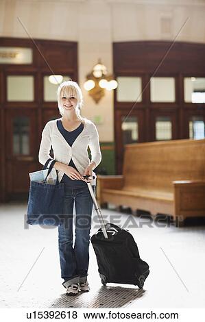 USA, Seattle, Young woman at train station standing with luggage and looking at camera View Large Photo Image Stock Photo - USA, Seattle, Young woman at train station standing with luggage and looking at camera. Fotosearch