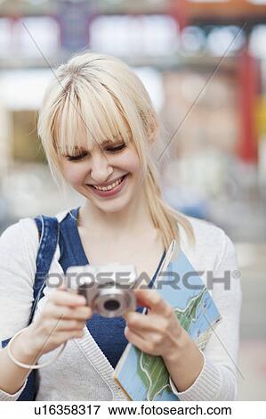 USA, Seattle, Young woman checking pictures at digital camera View Large Photo Image Stock Photo - USA, Seattle, Young woman checking pictures at digital camera. Fotosearch