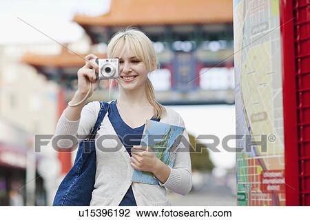 USA, Seattle, Young woman taking photos and holding map View Large Photo Image Stock Image - USA, Seattle, Young woman taking photos and holding map. Fotosearch