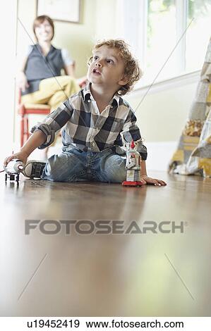 Stock Photo - USA, Utah, Boy (2-3) playing on floor. Fotosearch