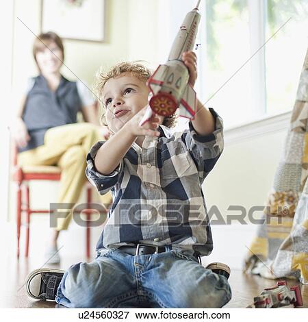 Stock Photo - USA, Utah, Boy (2-3) playing on floor. Fotosearch