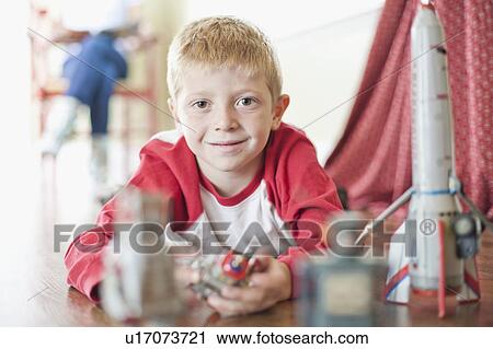 Stock Image - USA, Utah, Boy (6-7) playing on floor. Fotosearch