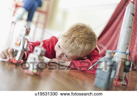Stock Image - USA, Utah, Boy (6-7) playing on floor. Fotosearch