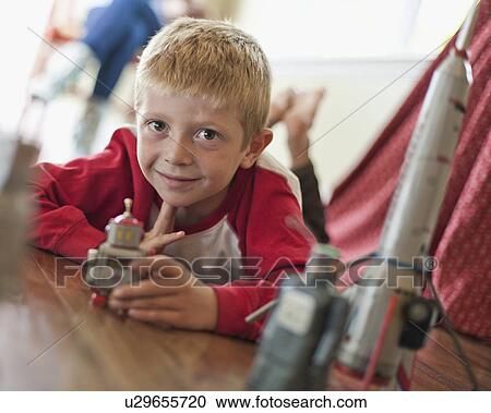 Stock Image - USA, Utah, Boy (6-7) playing on floor. Fotosearch