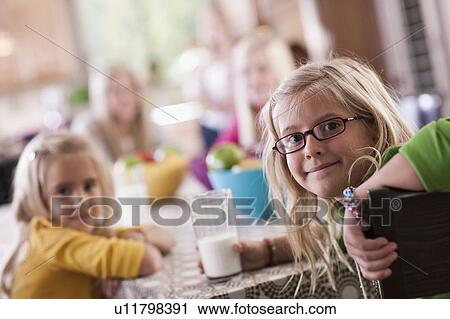 Stock Image - USA, Utah, family portrait of sisters (6-7, 8-9, 12-13, 14-15, 16-17) at table. Fotosearch