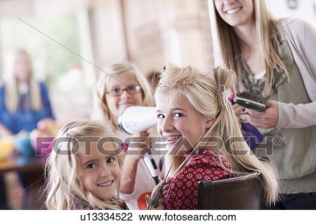 Stock Image - USA, Utah, family portrait of sisters (6-7, 8-9, 12-13, 14-15, 16-17) preparing hairs and having fun. Fotosearch