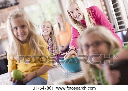 Stock Image - USA, Utah, family portrait of sisters (6-7, 8-9, 12-13, 14-15, 16-17) having fun at table. Fotosearch