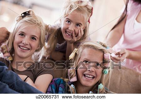 Stock Image - USA, Utah, family portrait of sisters (6-7, 8-9, 12-13, 14-15, 16-17) preparing hairs and having fun. Fotosearch
