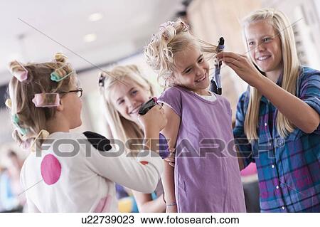 Stock Image - USA, Utah, family portrait of sisters (6-7, 8-9, 12-13, 14-15, 16-17) preparing hairs and having fun. Fotosearch