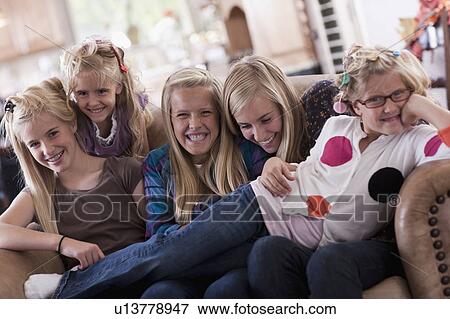 Stock Photo - USA, Utah, family portrait of sisters on sofa (6-7, 8-9, 12-13, 14-15, 16-17). Fotosearch