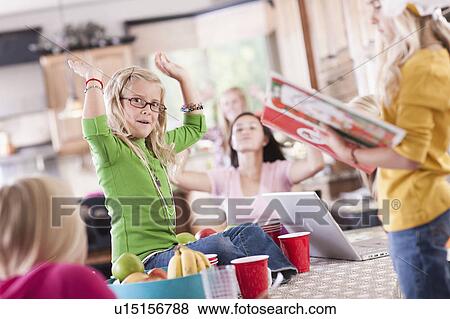 Stock Photo - USA, Utah, family portrait of sisters (6-7, 8-9, 12-13, 14-15, 16-17) having fun at table. Fotosearch