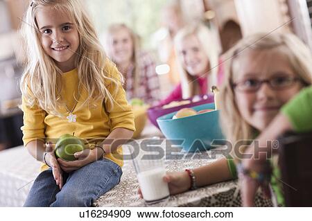 Stock Photo - USA, Utah, family portrait of sisters (6-7, 8-9, 12-13, 14-15, 16-17) at table. Fotosearch