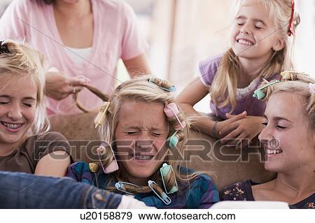 Stock Photo - USA, Utah, family portrait of sisters (6-7, 8-9, 12-13, 14-15, 16-17) preparing hairs and having fun. Fotosearch