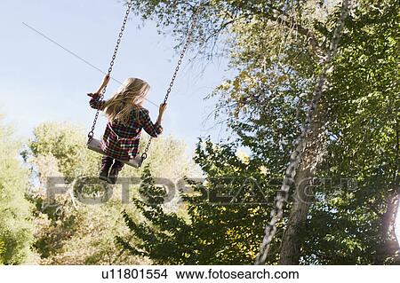 Picture - USA, Utah, girl (6-7) swinging on tree swing. Fotosearch
