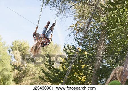USA, Utah, girl (6-7)swinging on tree swing View Large Photo Image Stock Image - USA, Utah, girl (6-7)swinging on tree swing. Fotosearch