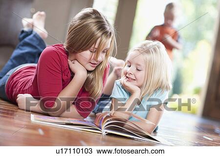 USA, Utah, Girls (6-7, 10-11) reading magazine on floor View Large Photo Image Stock Image - USA, Utah, Girls (6-7, 10-11) reading magazine on floor. Fotosearch