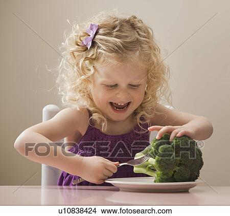 Picture - USA, Utah, Lehi, girl (2-3) eating broccoli. Fotosearch
