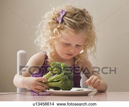 Picture - USA, Utah, Lehi, girl (2-3) eating broccoli. Fotosearch