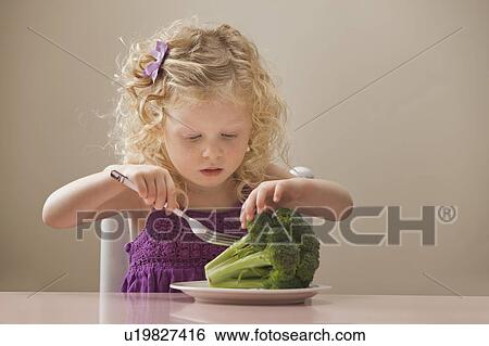 Stock Photograph - USA, Utah, Lehi, girl (2-3) eating broccoli. Fotosearch