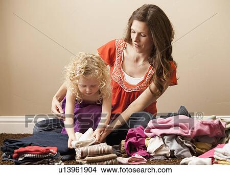 USA, Utah, Lehi, mother and daughter (2-3) folding laundry View Large Photo Image Picture - USA, Utah, Lehi, mother and daughter (2-3) folding laundry. Fotosearch