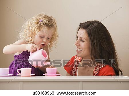 Stock Image - USA, Utah, Lehi, mother and daughter (2-30 having tea. Fotosearch
