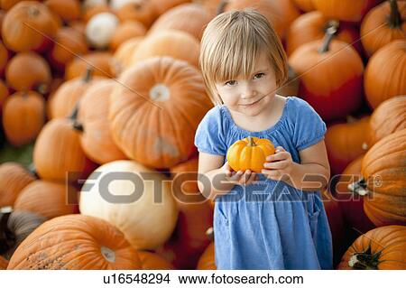Picture - USA, Utah, Orem, portrait of girl (2-3) holding pumpkin. Fotosearch