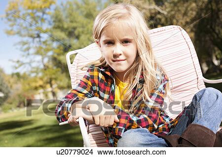 USA, Utah, outdoor portrait of blonde girl (6-7) sitting on deck chair View Large Photo Image Picture - USA, Utah, outdoor portrait of blonde girl (6-7) sitting on deck chair. Fotosearch