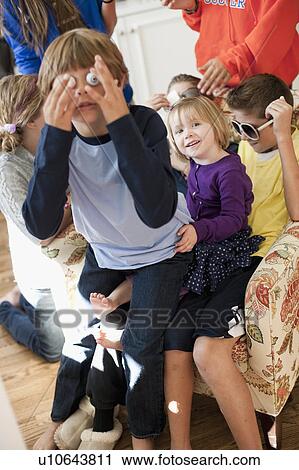 Stock Image - USA, Utah, Portrait of kids (2-3, 6-7, 8-9, 10-11, 10-11) playing in living room. Fotosearch
