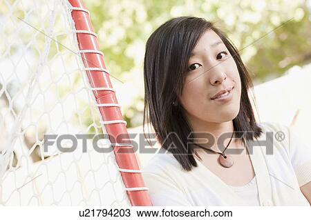Stock Image - USA, Utah, portrait of young woman near goalpost. Fotosearch