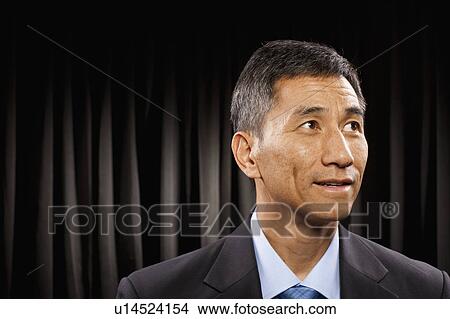 Picture - USA, Utah, Provo, Businessman standing in front of black curtain. Fotosearch
