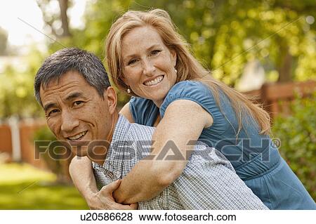 Stock Photo - USA, Utah, Provo, Portrait of smiling mature couple in garden. Fotosearch