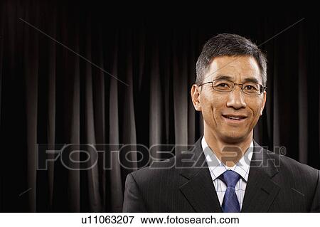 USA, Utah, Provo, Portrait of businessman standing in front of black curtain View Large Photo Image Stock Photo - USA, Utah, Provo, Portrait of businessman standing in front of black curtain. Fotosearch