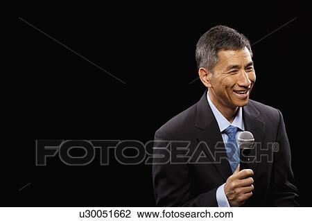 USA, Utah, Provo, Smiling businessman with microphone standing ion stage View Large Photo Image Stock Image - USA, Utah, Provo, Smiling businessman with microphone standing ion stage. Fotosearch