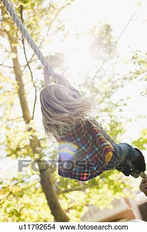 Picture - USA, Utah, rear view of girl (6-7) hanging on rope. Fotosearch