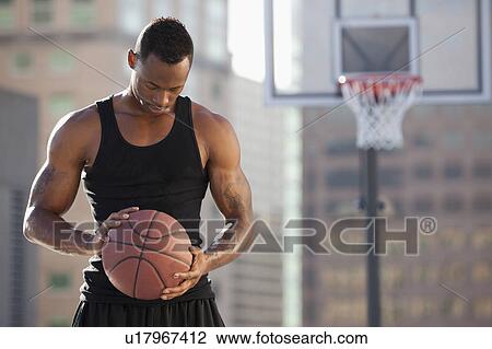 Stock Image - USA, Utah, Salt Lake City, basketball player holding basketball. Fotosearch