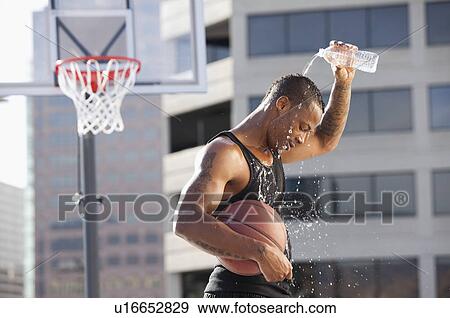 Stock Photo - USA, Utah, Salt Lake City, basketball player pouring water on head. Fotosearch