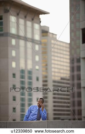 USA, Utah, Salt Lake City, Young businessman talking on mobile phone in front of skyscrapers View Large Photo Image Stock Image - USA, Utah, Salt Lake City, Young businessman talking on mobile phone in front of skyscrapers. Fotosearch