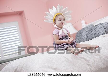 USA, Utah, small girl (2-3) with plume sitting on bed View Large Photo Image Stock Photograph - USA, Utah, small girl (2-3) with plume sitting on bed. Fotosearch
