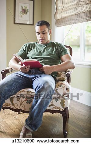 Stock Image - USA, Utah, Young man reading book. Fotosearch