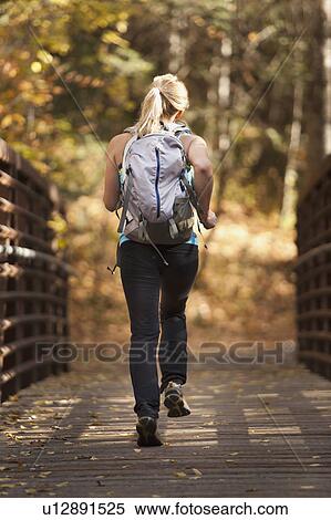 Stock Photography - USA, Utah, young woman jogging on footbridge. Fotosearch