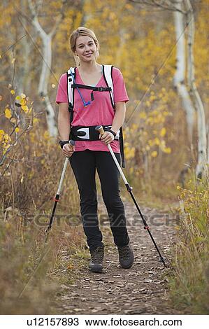 Stock Image - USA, Utah, young woman walking on trail. Fotosearch