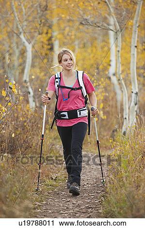 Stock Image - USA, Utah, young woman walking on trail. Fotosearch