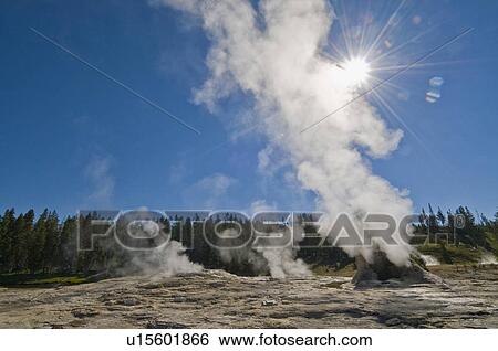 Stock Photograph - USA, Wyoming, Sun over steaming thermal pool. Fotosearch