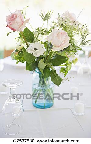 Vase of roses on set dinner table with glasses View Large Photo Image Stock Image - Vase of roses on set dinner table with glasses. Fotosearch