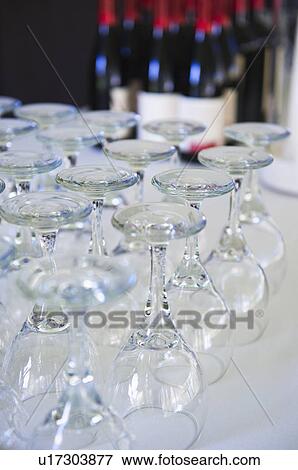 Wine glasses on table with bottles in background View Large Photo Image Stock Photo - Wine glasses on table with bottles in background. Fotosearch