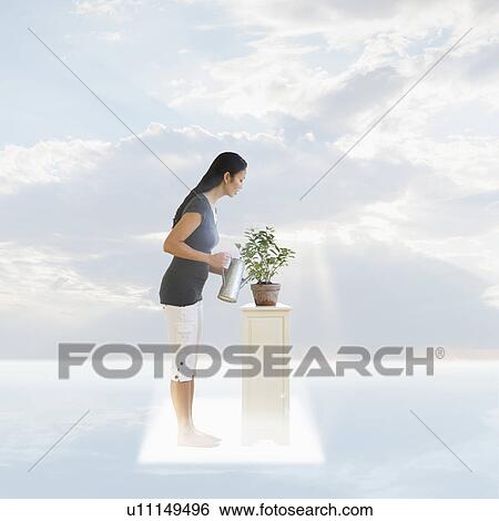 Stock Photograph - Woman watering plant under cloudy sky. Fotosearch