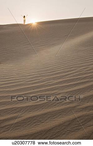 Woman with arms up, standing in desert View Large Photo Image Stock Photo - Woman with arms up, standing in desert. Fotosearch