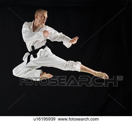 Young man performing karate kick on black background View Large Photo Image Stock Photo - Young man performing karate kick on black background. Fotosearch