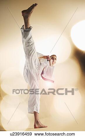 Stock Photo - Young man performing karate kick. Fotosearch